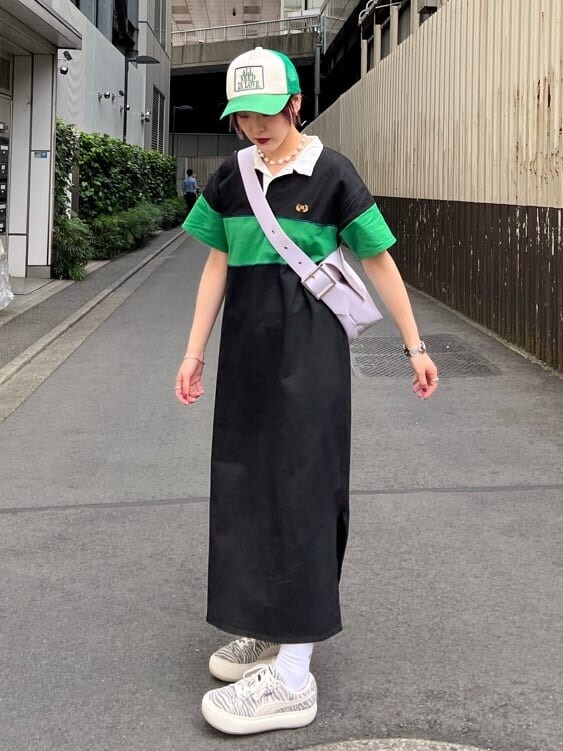 ブラック系のワンピース、パープル系のハンドバッグ、グリーン系のキャップを着用したレディースの夏コーディネートの5枚目の写真