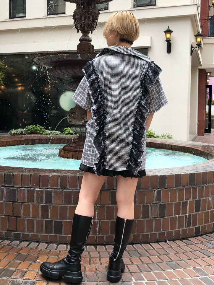 ブラック系のスカート、ブラック系のブーツ、ホワイト系のTシャツ/カットソーを着用したレディースの春コーディネートの4枚目の写真