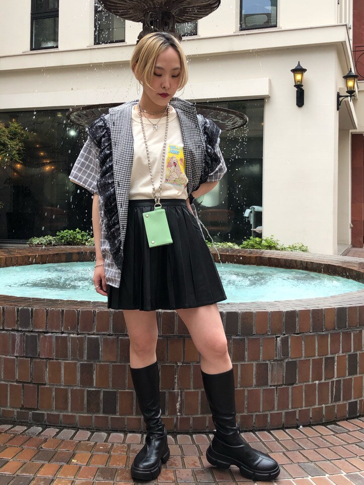 ブラック系のスカート、ブラック系のブーツ、ホワイト系のTシャツ/カットソーを着用したレディースの春コーディネートの2枚目の写真