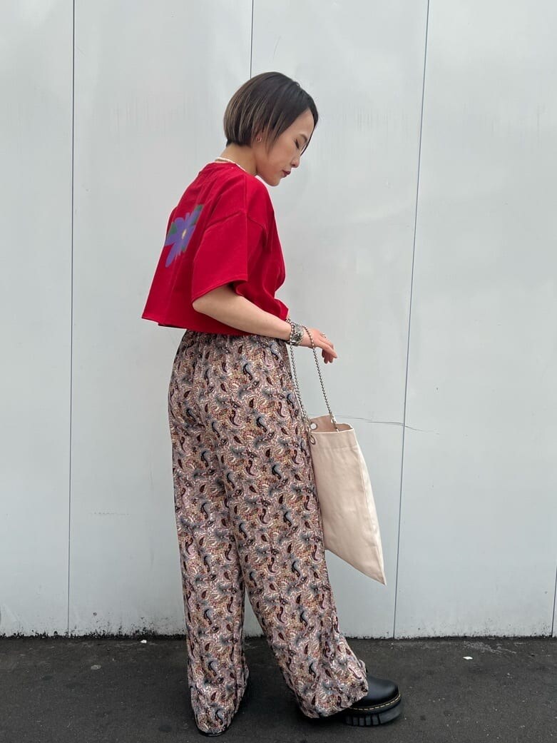 ホワイト系のトートバッグ、ブラック系のその他シューズ、レッド系のTシャツ/カットソーを着用したレディースの春コーディネートの3枚目の写真