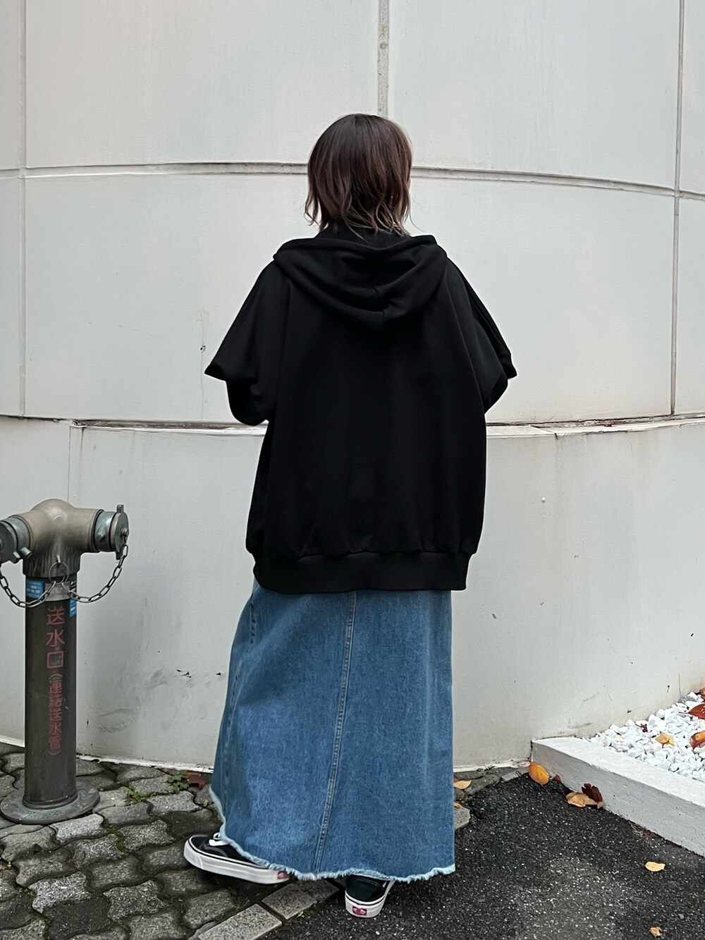 ブルー系のスカート、ブラック系のパーカー、ブルー系のタンクトップを着用したレディースの春コーディネートの4枚目の写真