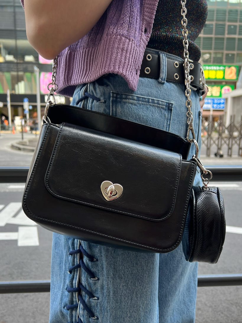 ブラック系のハンドバッグ、ブラック系のニット/セーター、ブルー系のデニムパンツを着用したレディースの夏コーディネートの9枚目の写真