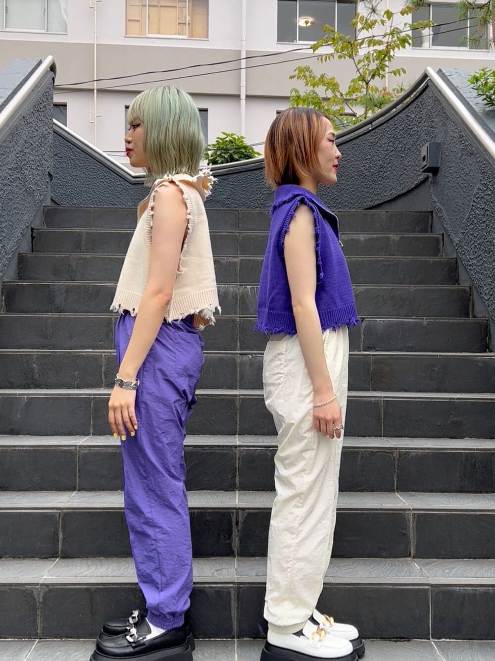 パープル系のベスト、ホワイト系のその他シューズ、ホワイト系のその他パンツを着用したレディースの秋コーディネートの2枚目の写真