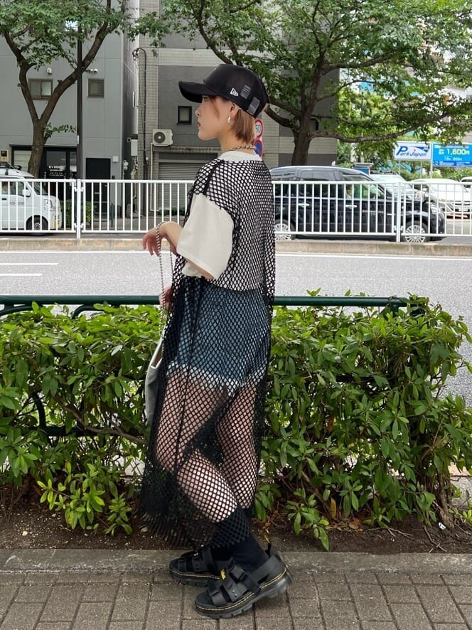 ブルー系のデニムパンツ、ブラック系のワンピース、ホワイト系のTシャツ/カットソーを着用したレディースの夏コーディネートの2枚目の写真