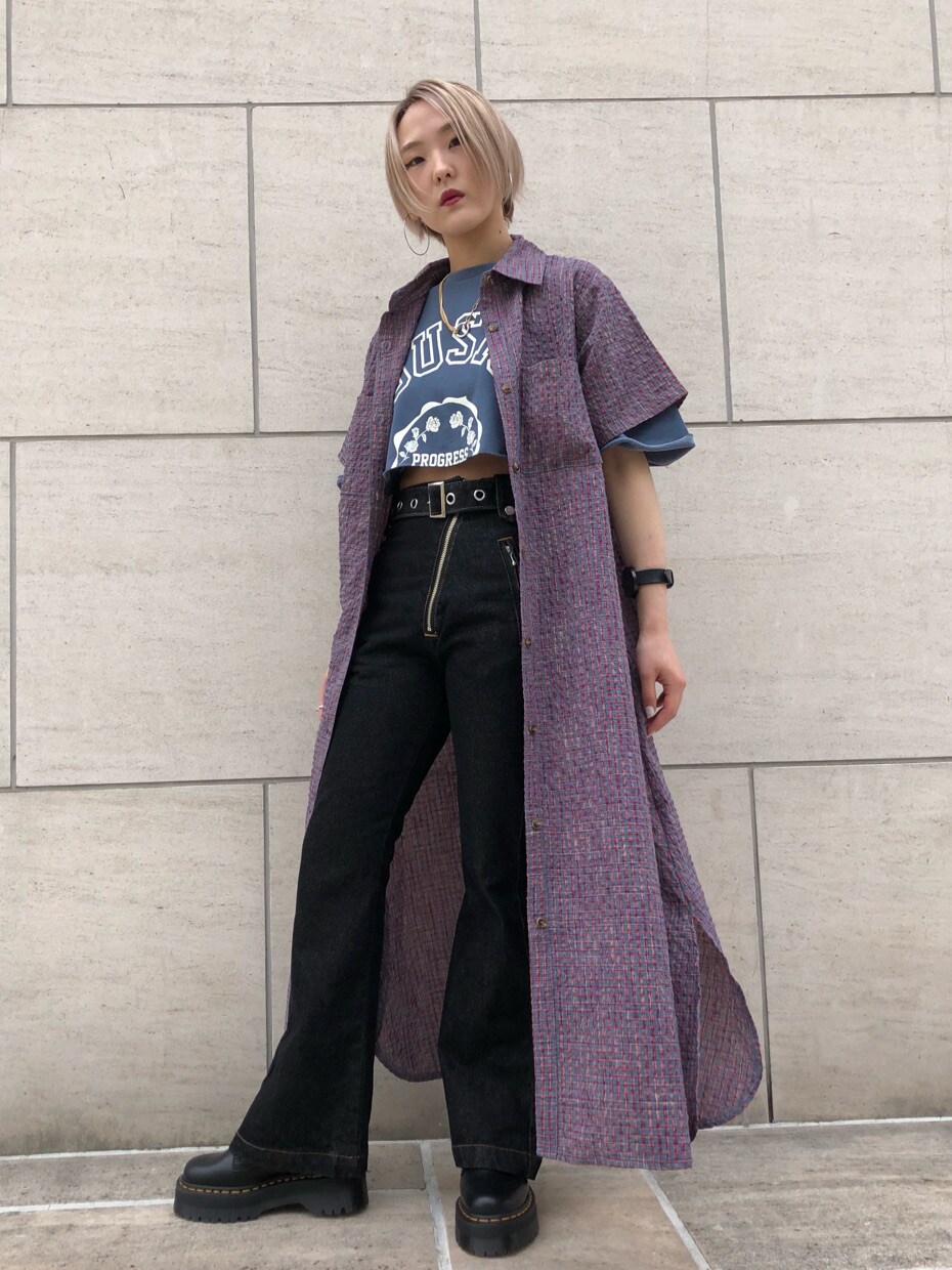 ブラック系のブーツ、ブルー系のワンピース、ブラック系のデニムパンツを着用したレディースの夏コーディネートの2枚目の写真