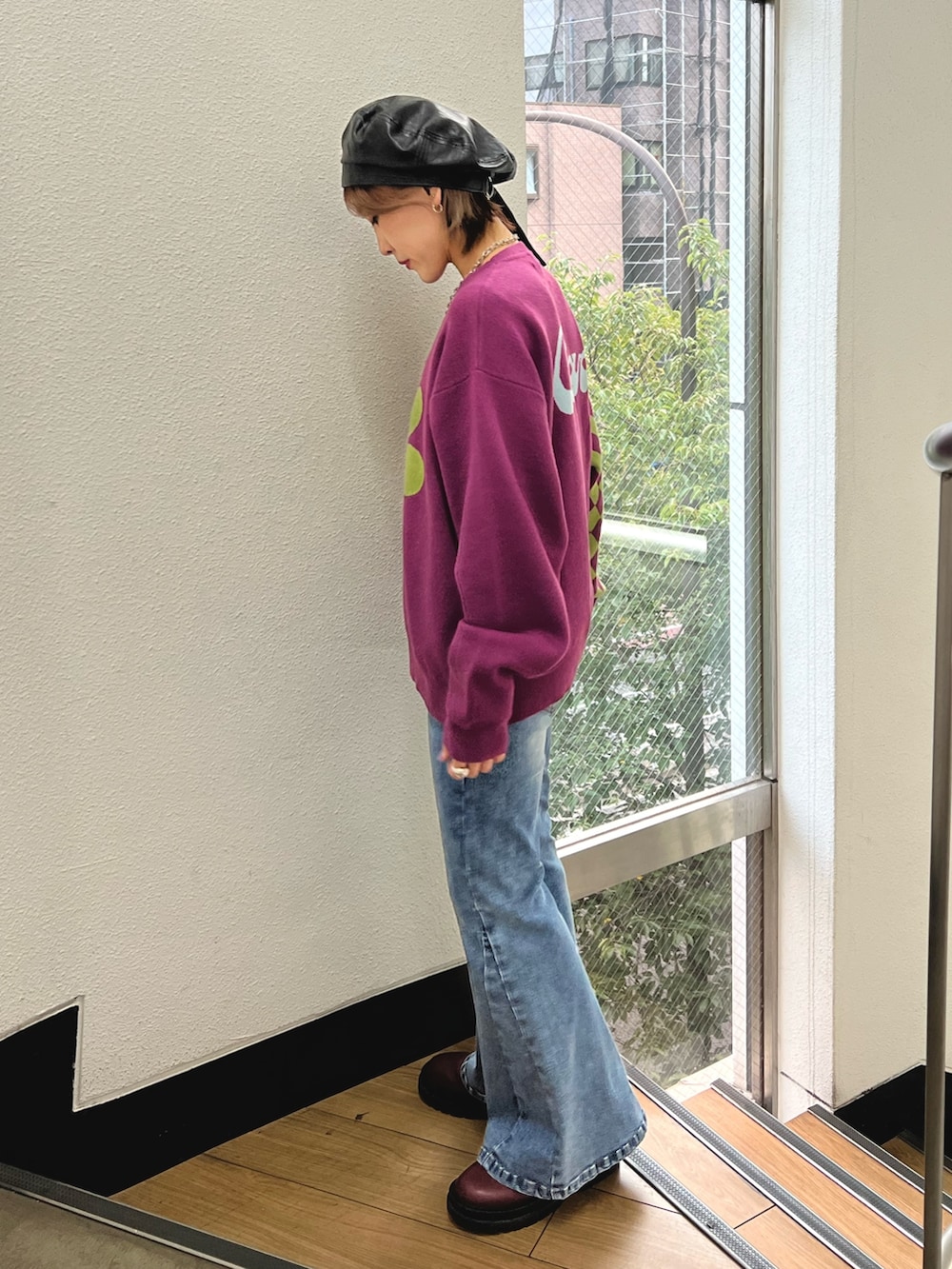 パープル系のニット/セーター、ブルー系のデニムパンツ、レッド系のブーツを着用したレディースの秋コーディネートの3枚目の写真