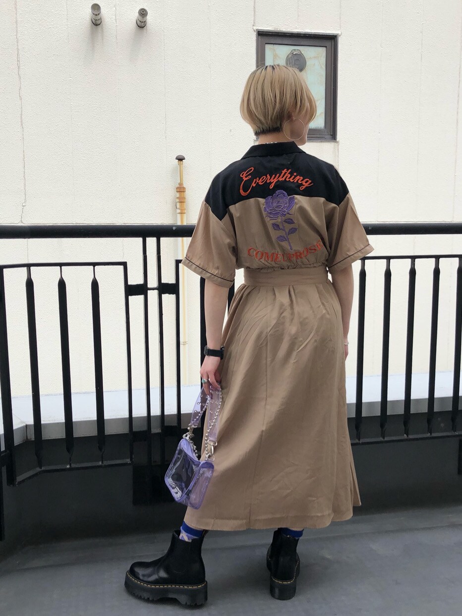 ブラック系のブーツ、パープル系のショルダーバッグ、ベージュ系のワンピースを着用したレディースの春コーディネートの3枚目の写真