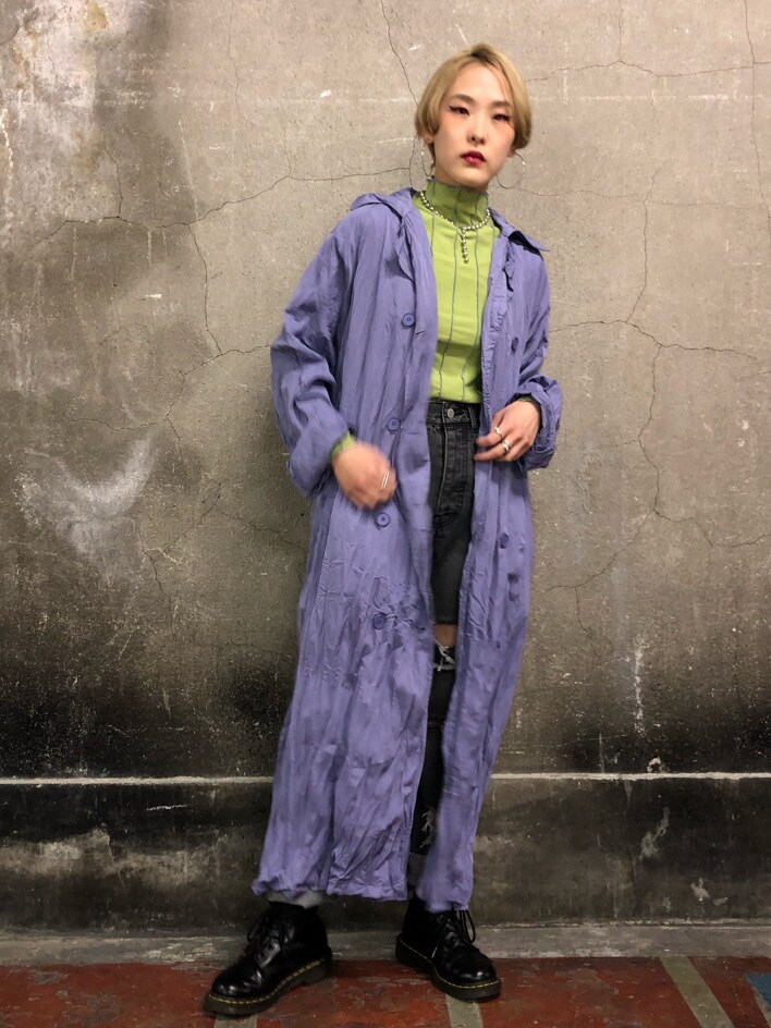 ブラック系のデニムパンツ、グリーン系のTシャツ/カットソー、パープル系のトレンチコートを着用したレディースの冬コーディネートの3枚目の写真