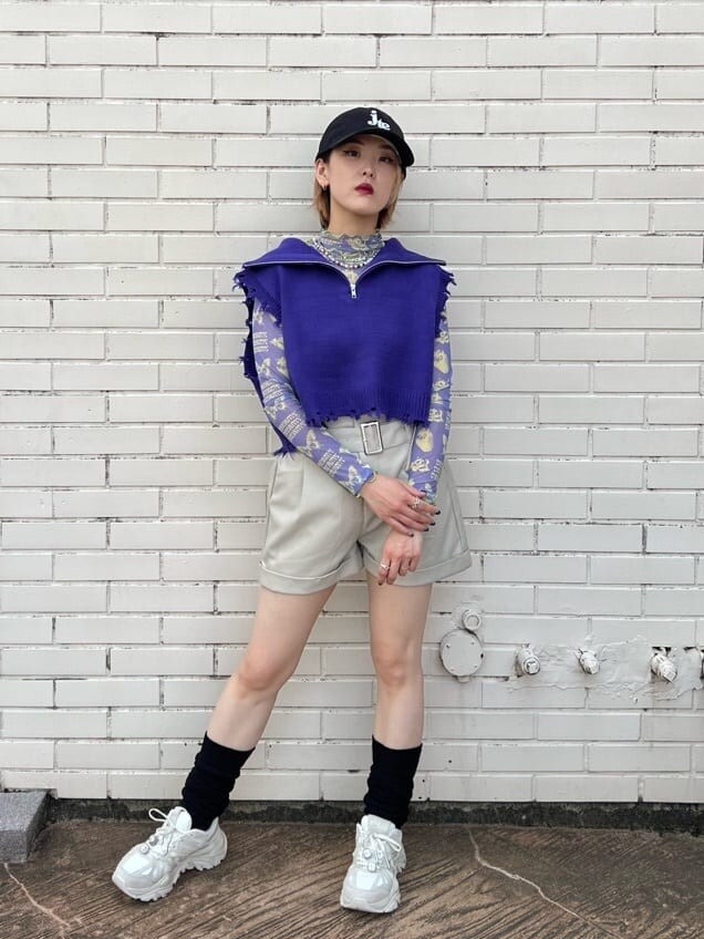 ホワイト系のスニーカー、パープル系のベスト、パープル系のその他トップスを着用したレディースの秋コーディネートの4枚目の写真