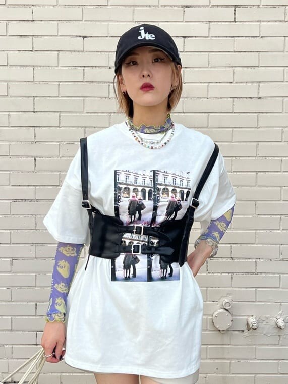 ホワイト系のスニーカー、ホワイト系のバックパック/リュック、ホワイト系のTシャツ/カットソーを着用したレディースの秋コーディネートの7枚目の写真