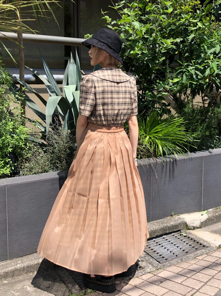 ベージュ系のワンピース、ブラック系のサンダル、ブラック系のハットを着用したレディースの夏コーディネートの3枚目の写真