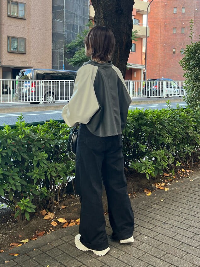 ブラック系のニット/セーター、ホワイト系のスニーカー、ブラック系のデニムパンツを着用したレディースの秋コーディネートの3枚目の写真