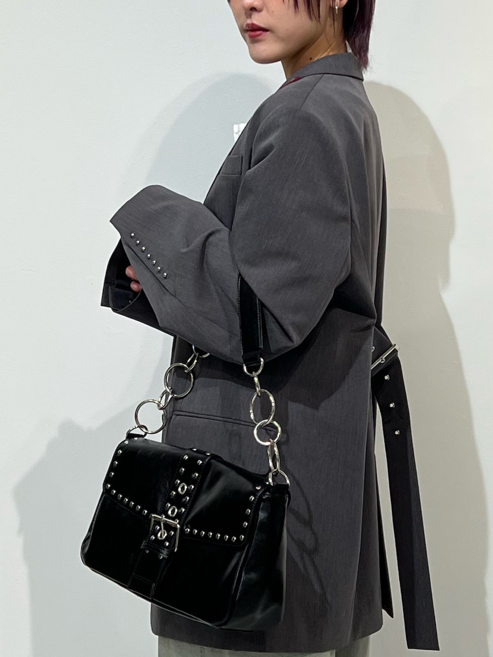 グレー系のテーラードジャケット、ブラック系のパンプス、ブルー系のデニムパンツを着用したレディースの春コーディネートの6枚目の写真