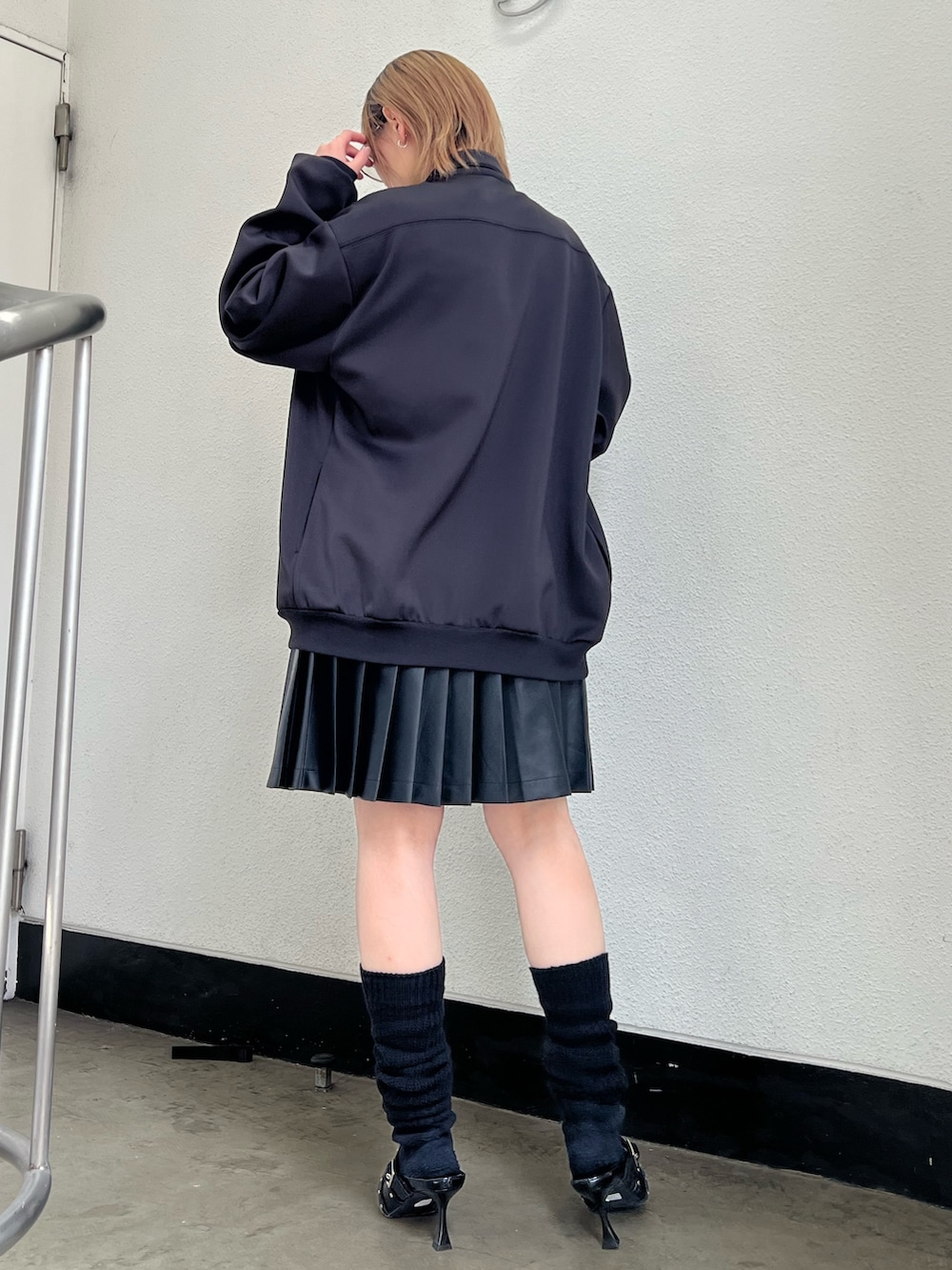 ブラック系のジャージ、ブラック系のパンプス、ブラック系のスカートを着用したレディースの春コーディネートの3枚目の写真