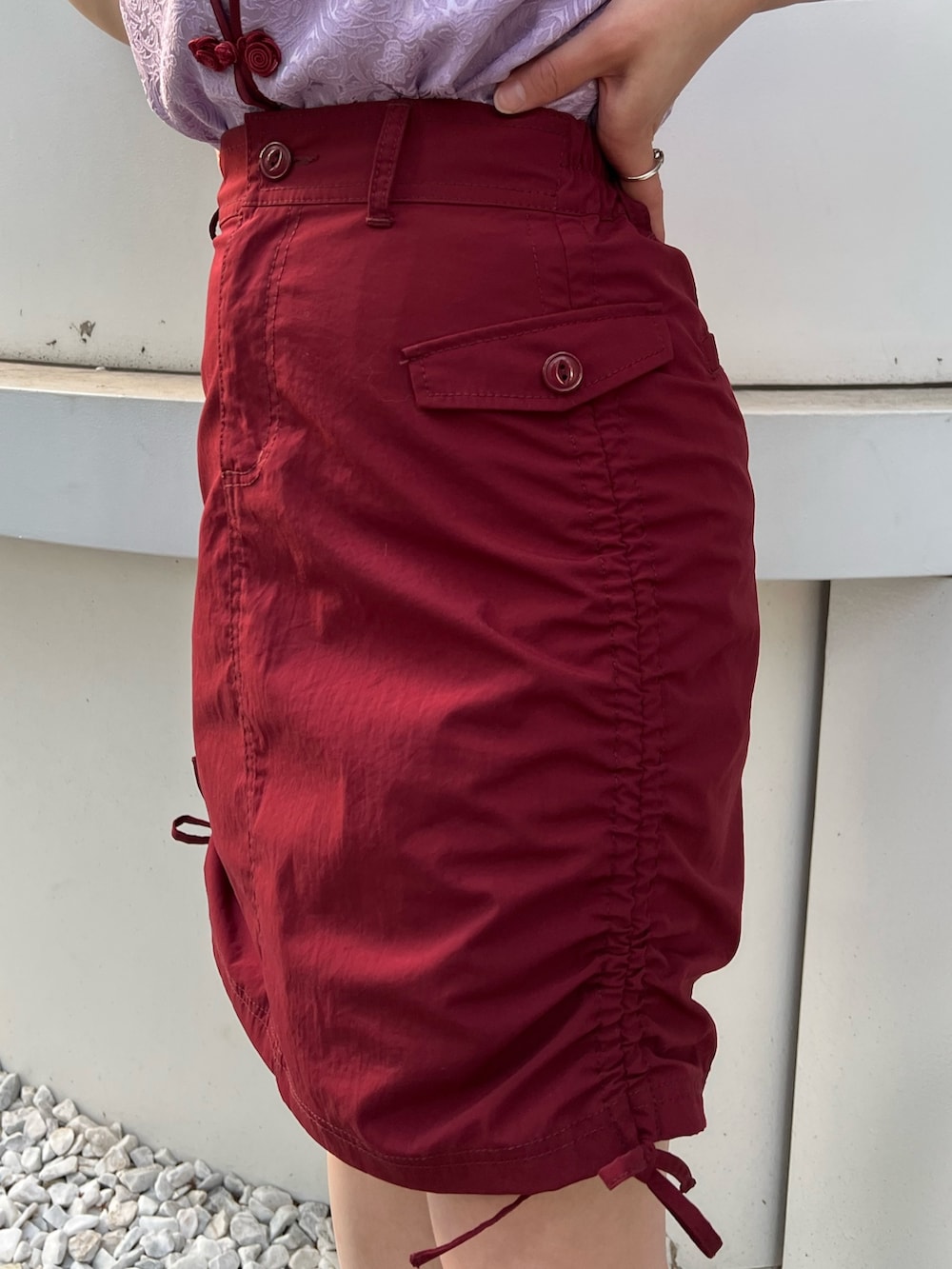 パープル系のシャツ/ブラウス、レッド系のスカート、ブラック系のキャップを着用したレディースの春コーディネートの8枚目の写真