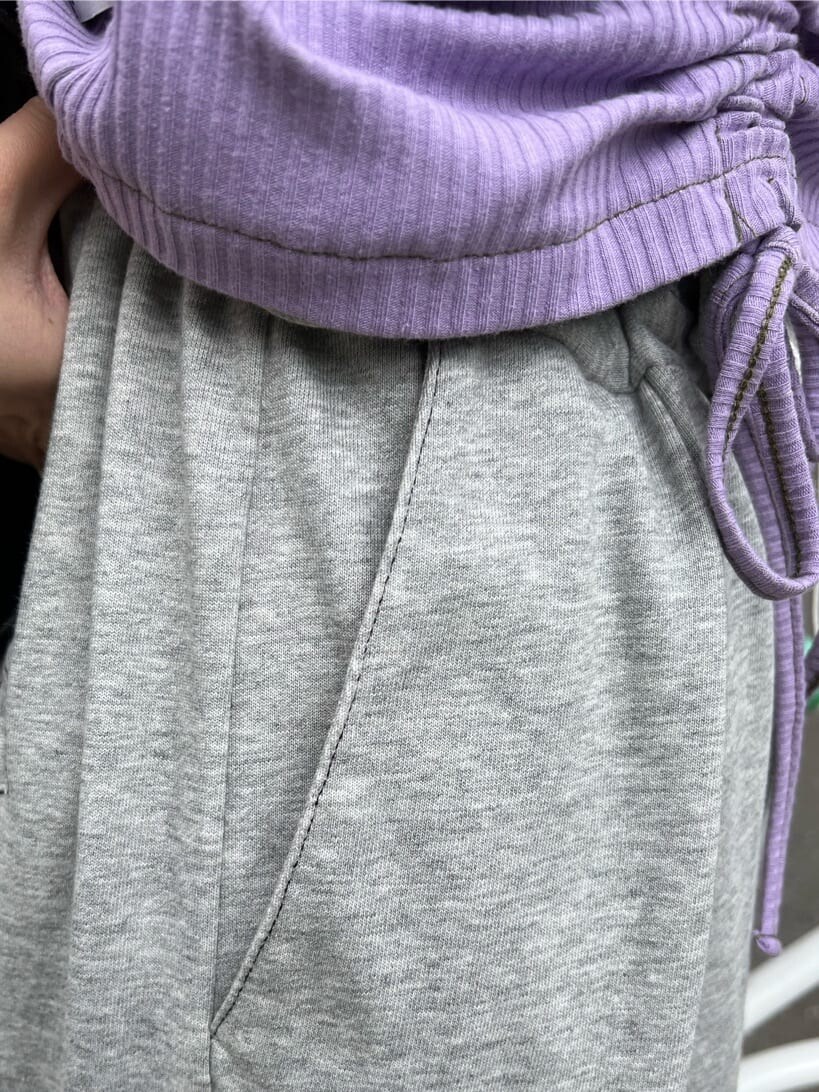 ブラック系のハンドバッグ、パープル系のTシャツ/カットソー、グレー系のその他パンツを着用したレディースの夏コーディネートの9枚目の写真