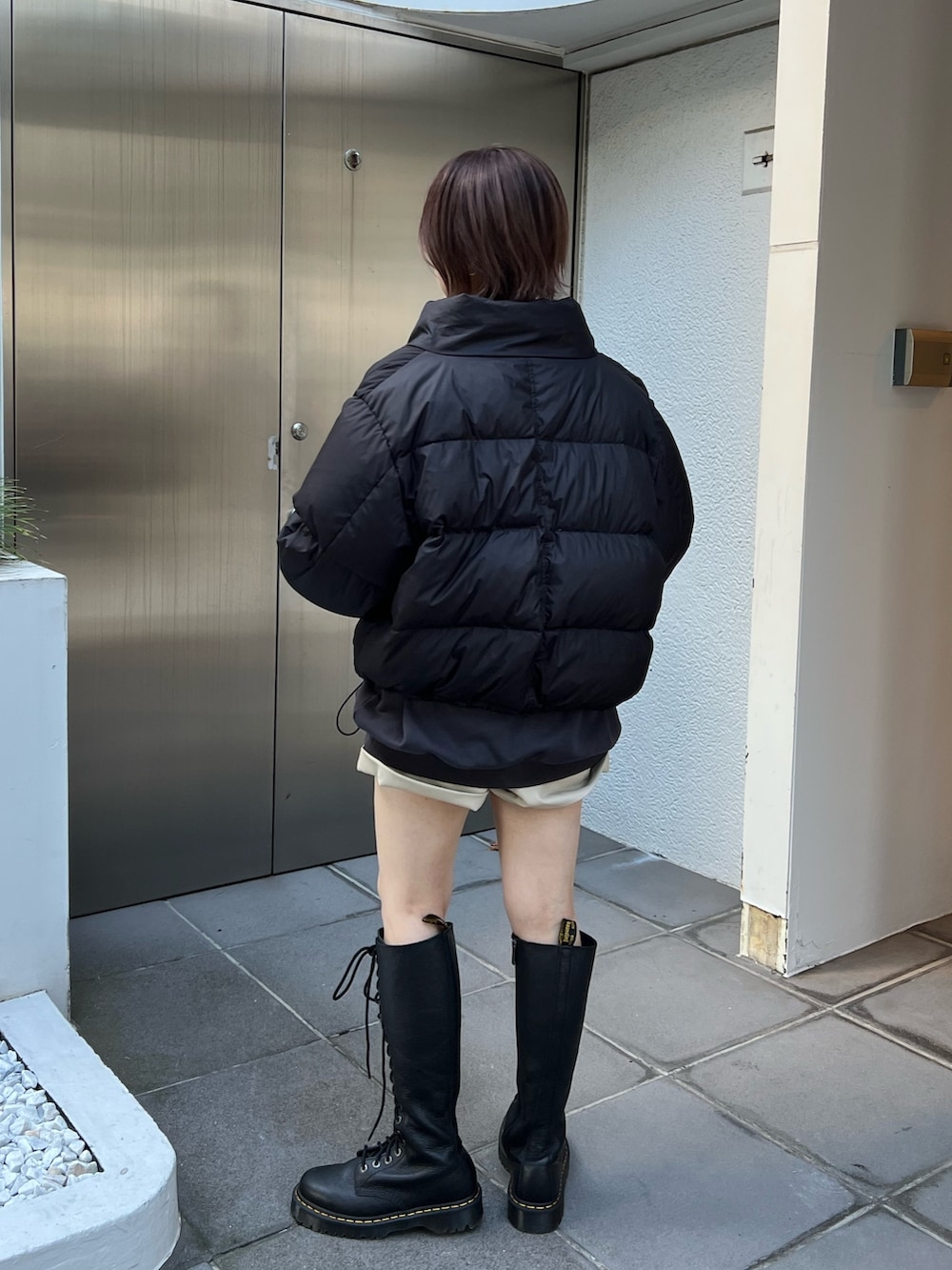 ブラック系のブルゾン、ブラック系のスウェット、ホワイト系のその他パンツを着用したレディースの冬コーディネートの3枚目の写真