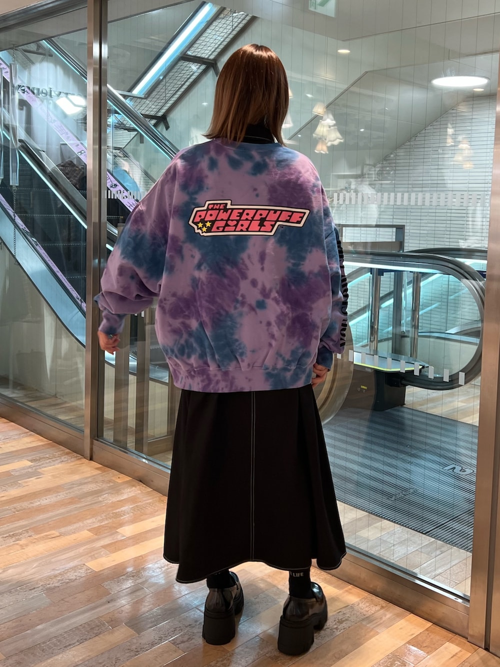 パープル系のスウェット、ブラック系のワンピース、ブラック系のローファーを着用したレディースの春コーディネートの3枚目の写真