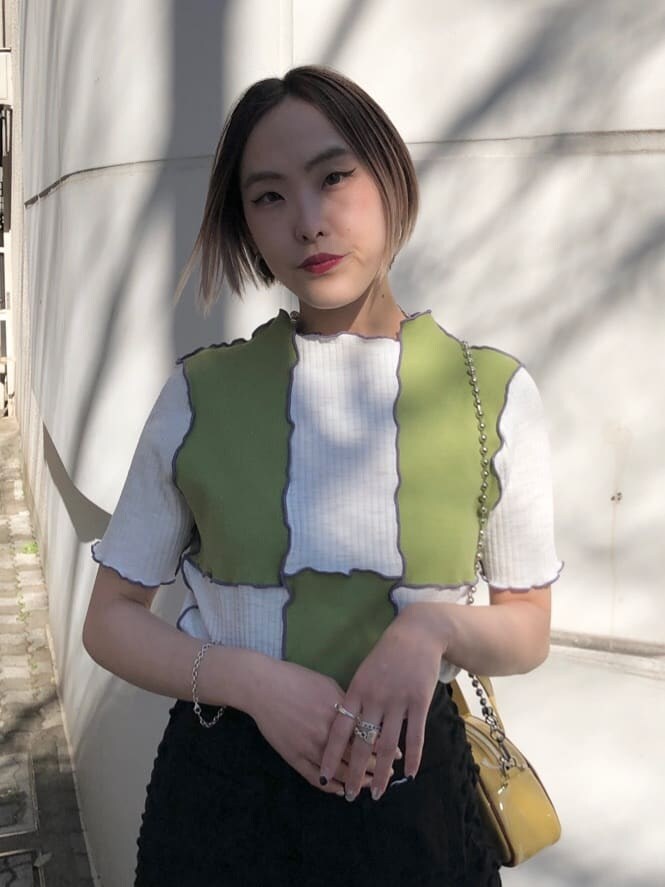 イエロー系のボストンバッグ、ブラック系のデニムパンツ、グリーン系のTシャツ/カットソーを着用したレディースの夏コーディネートの7枚目の写真