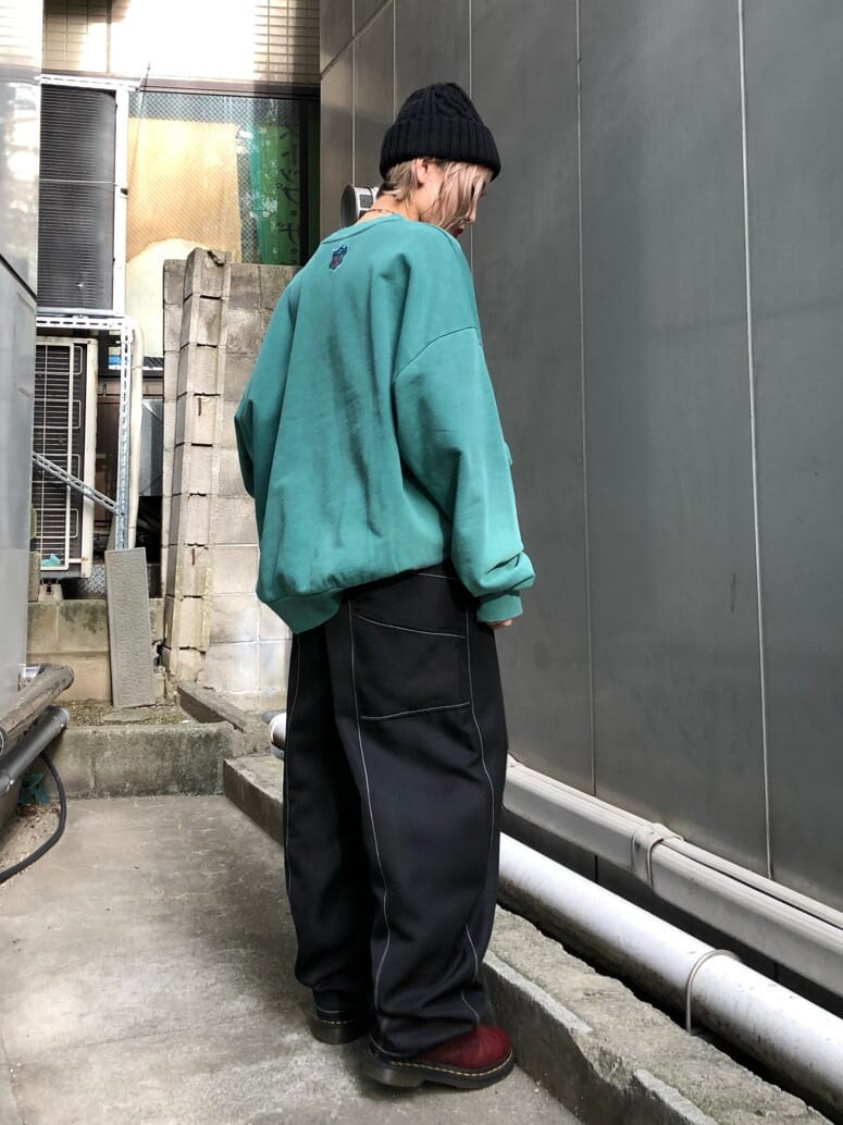 グリーン系のスウェット、ブラック系のスラックス、ブラック系のニットキャップ/ビーニーを着用したレディースの秋コーディネートの3枚目の写真