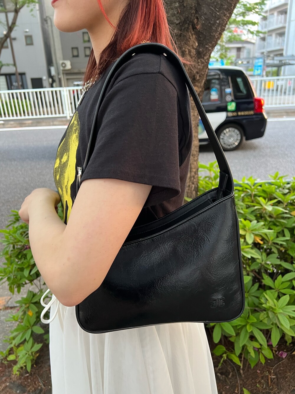 ブラック系のTシャツ/カットソー、ホワイト系のスカート、ブラック系のハンドバッグを着用したレディースの夏コーディネートの9枚目の写真