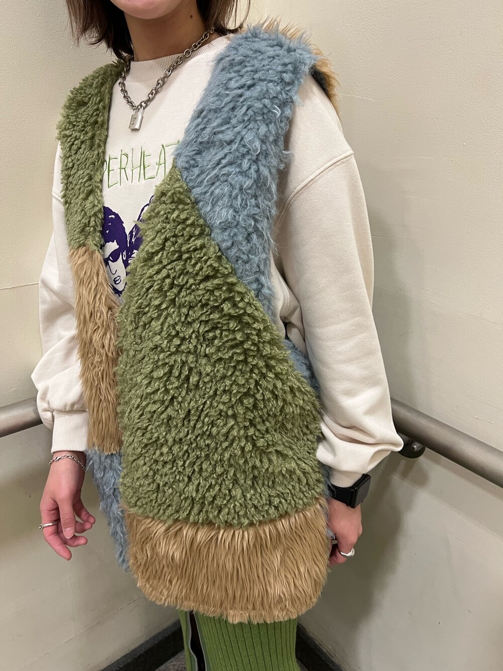 その他のベスト、ホワイト系のニット/セーター、グリーン系のスカートを着用したレディースの冬コーディネートの5枚目の写真