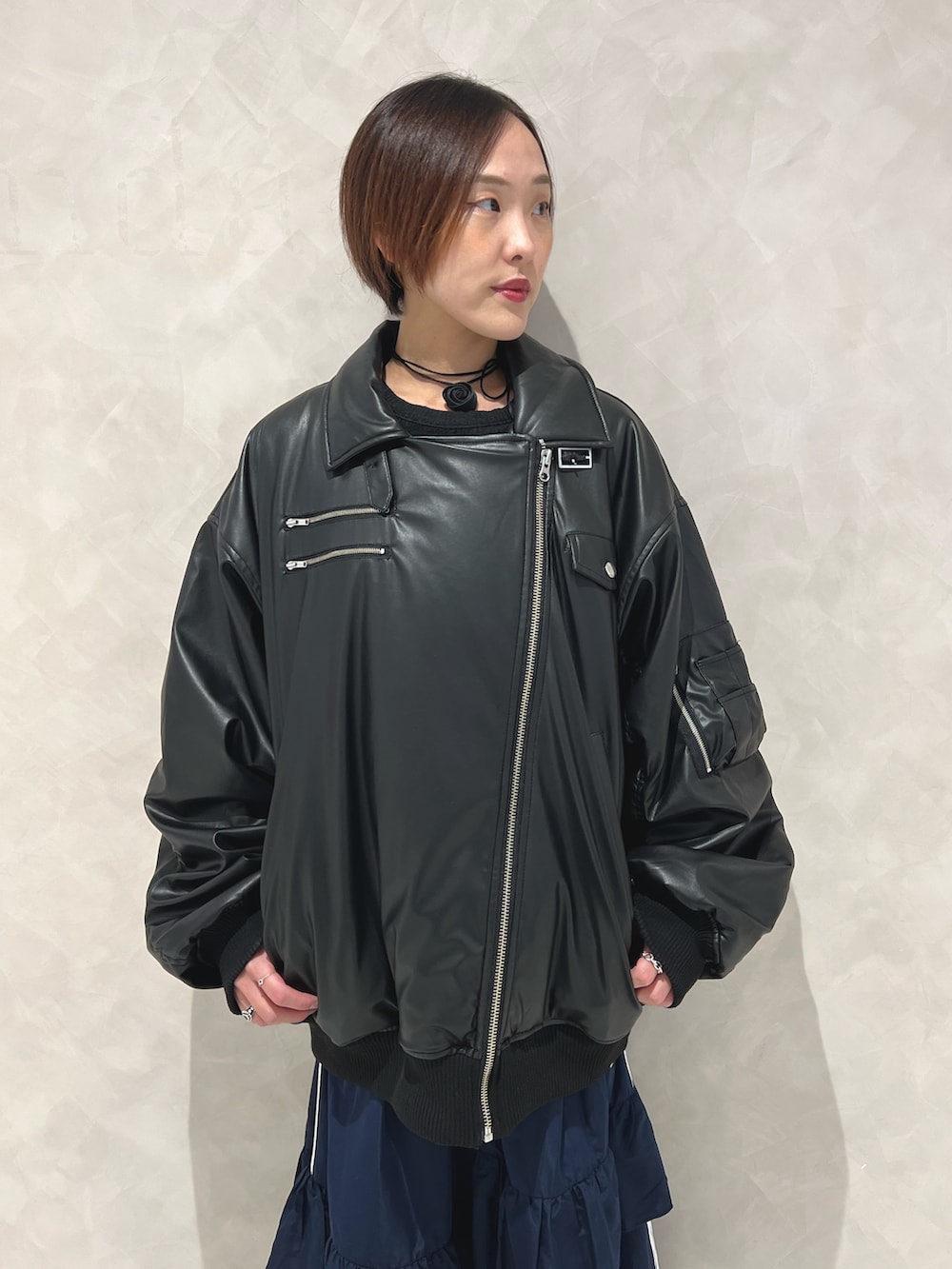 ブラック系のブルゾン、ブルー系のスカート、ブラック系のブーツを着用したレディースの秋コーディネートの6枚目の写真