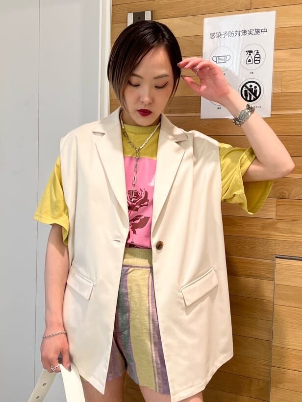 ホワイト系のブーツ、ホワイト系のベスト、ホワイト系のハンドバッグを着用したレディースの春コーディネートの5枚目の写真