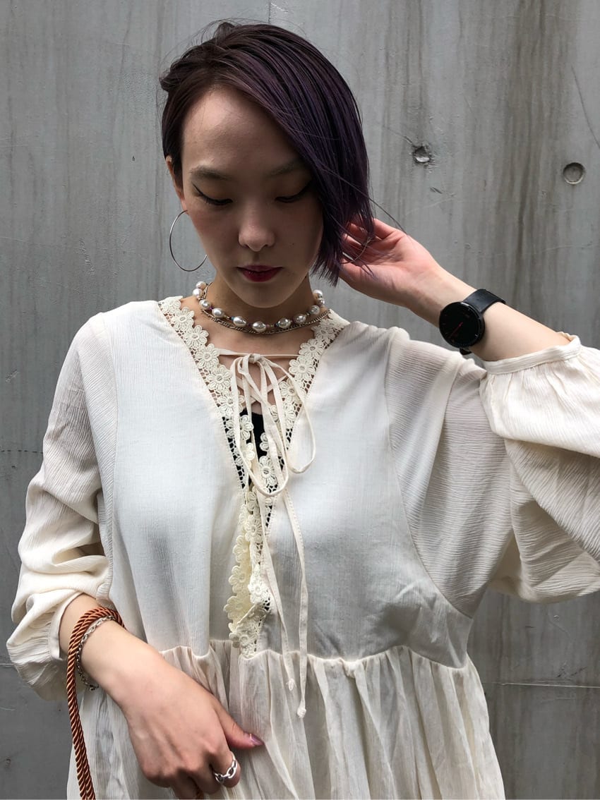 ホワイト系のワンピース、ホワイト系のパンプス、オレンジ系のハンドバッグを着用したレディースの夏コーディネートの5枚目の写真