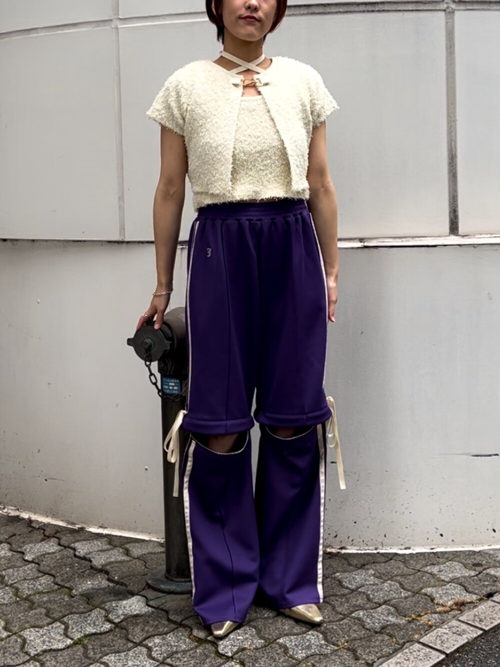 ホワイト系のアンサンブル、パープル系のその他パンツ、ゴールド系のパンプスを着用したレディースの夏コーディネートの7枚目の写真