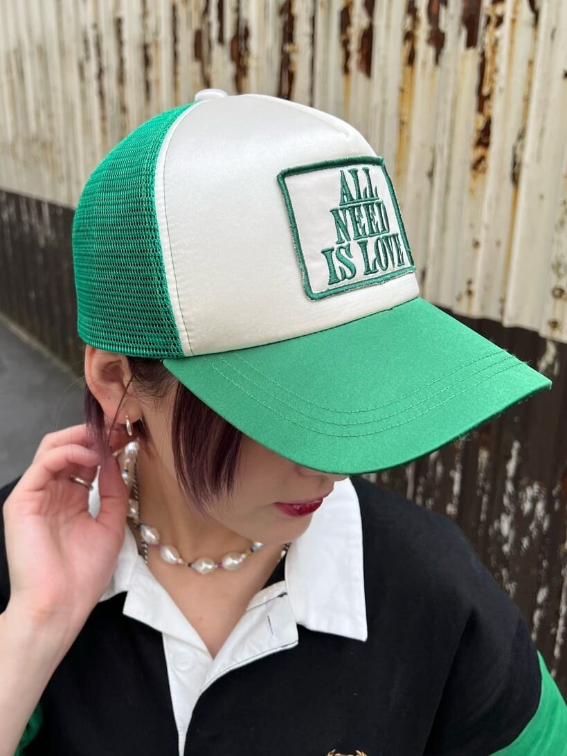 ブラック系のワンピース、パープル系のハンドバッグ、グリーン系のキャップを着用したレディースの夏コーディネートの9枚目の写真