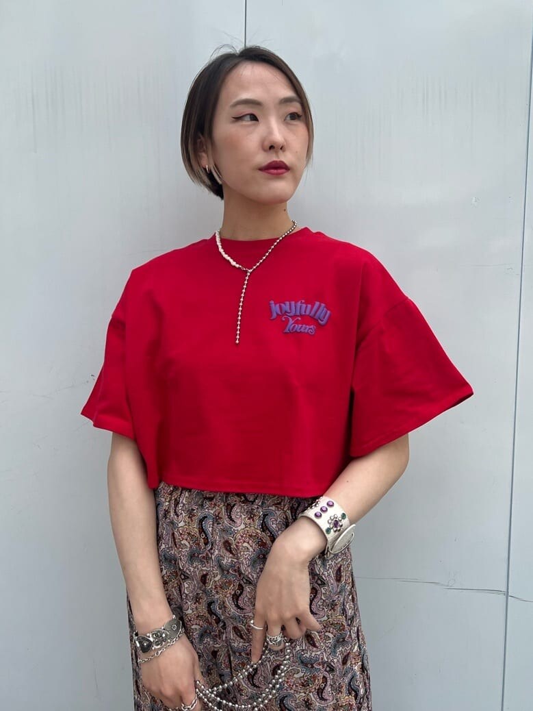 ホワイト系のトートバッグ、ブラック系のその他シューズ、レッド系のTシャツ/カットソーを着用したレディースの春コーディネートの5枚目の写真