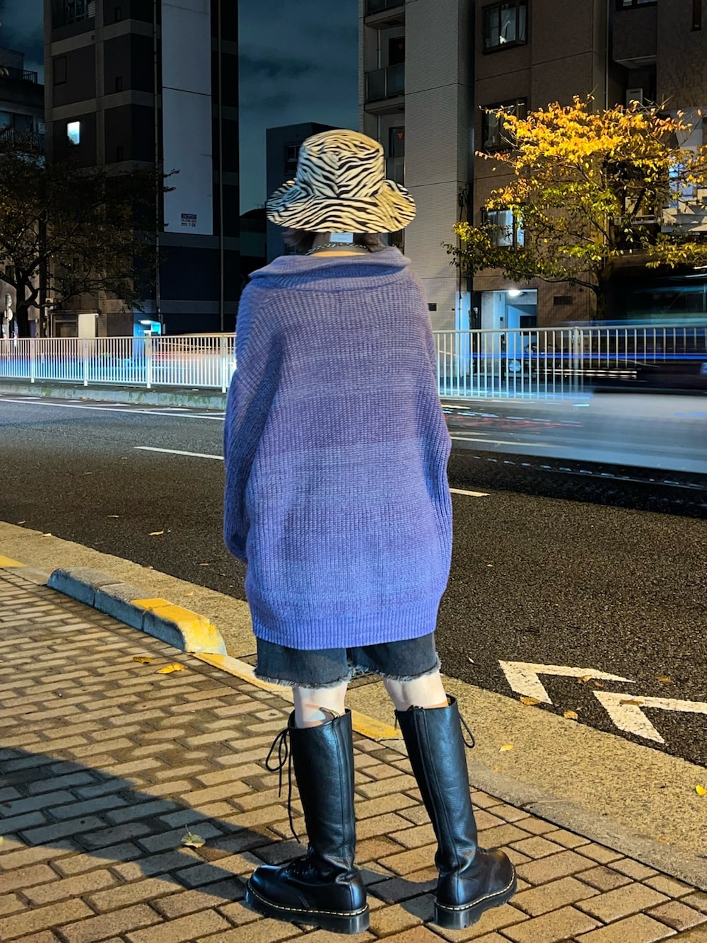 パープル系のニット/セーター、ブラック系のデニムパンツ、ホワイト系のハットを着用したレディースの冬コーディネートの3枚目の写真