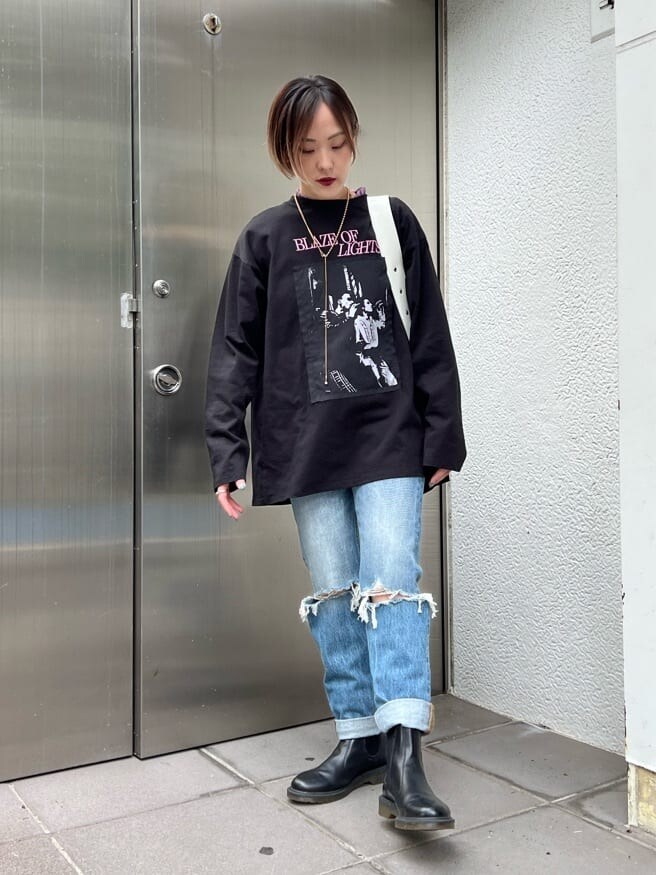 ブルー系のデニムパンツ、ホワイト系のハンドバッグ、パープル系のTシャツ/カットソーを着用したレディースの夏コーディネートの2枚目の写真