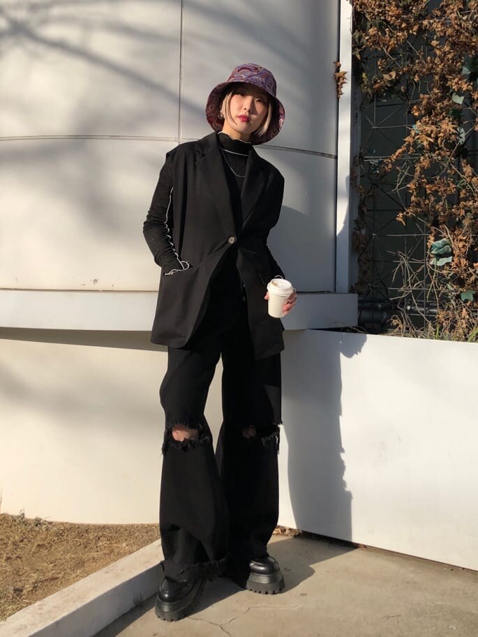 ブラック系のベスト、ブラック系のデニムパンツ、ブラック系のTシャツ/カットソーを着用したレディースの春コーディネートの2枚目の写真