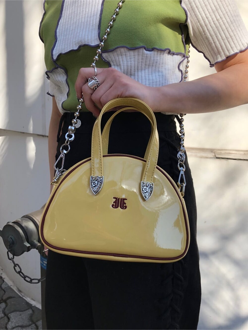 イエロー系のボストンバッグ、ブラック系のデニムパンツ、グリーン系のTシャツ/カットソーを着用したレディースの夏コーディネートの10枚目の写真