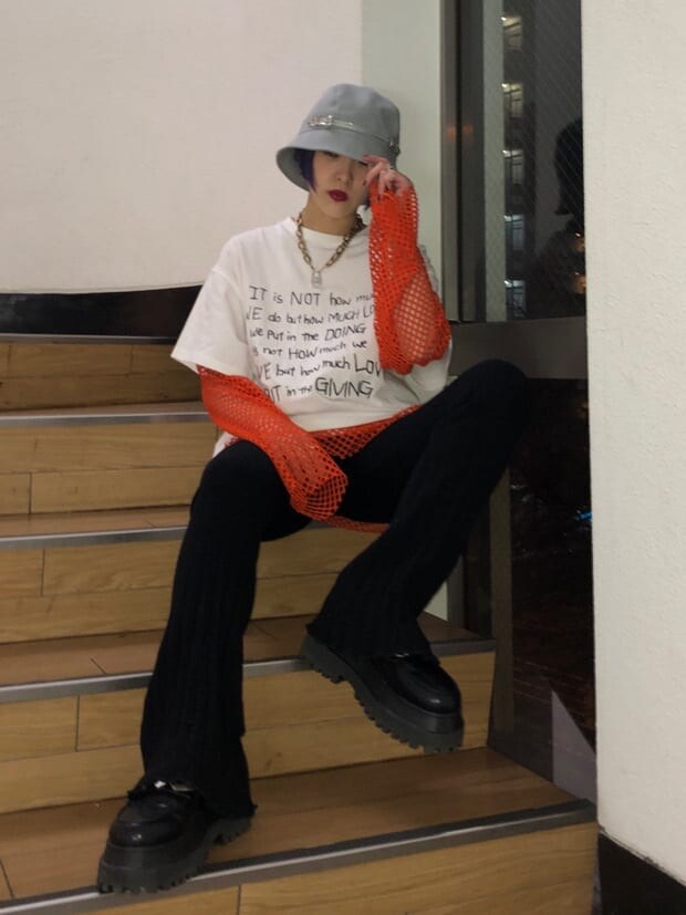 ブラック系のその他パンツ、オレンジ系のTシャツ/カットソー、ホワイト系のTシャツ/カットソーを着用したレディースの冬コーディネートの2枚目の写真