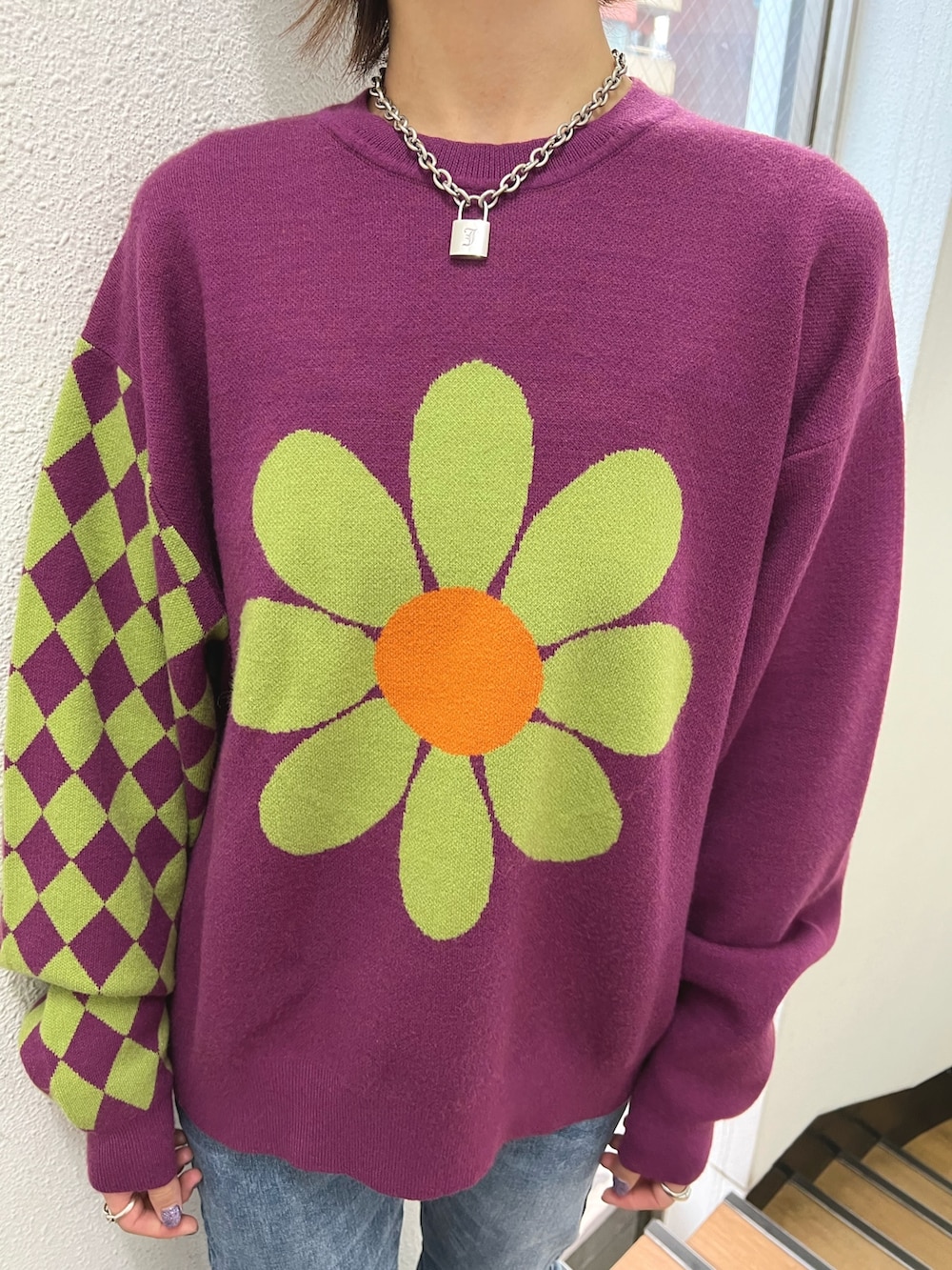 パープル系のニット/セーター、ブルー系のデニムパンツ、レッド系のブーツを着用したレディースの秋コーディネートの6枚目の写真