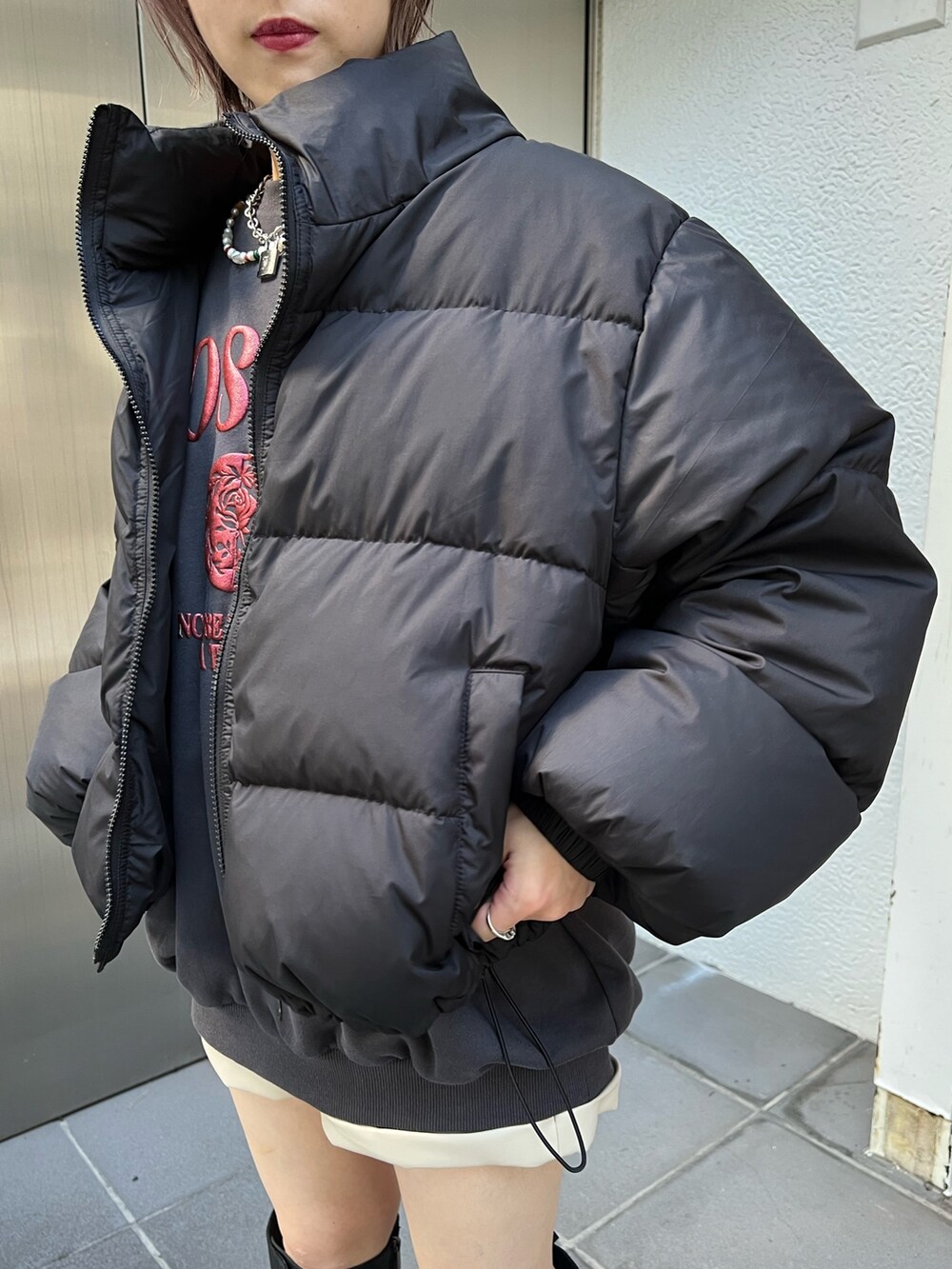 ブラック系のブルゾン、ブラック系のスウェット、ホワイト系のその他パンツを着用したレディースの冬コーディネートの6枚目の写真