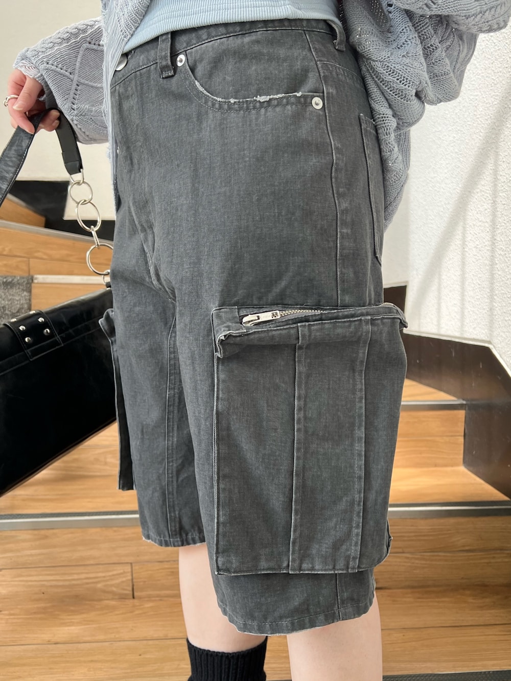 ブラック系のパンプス、ブラック系のカーゴパンツ、ブルー系のキャミソールを着用したレディースの春コーディネートの10枚目の写真