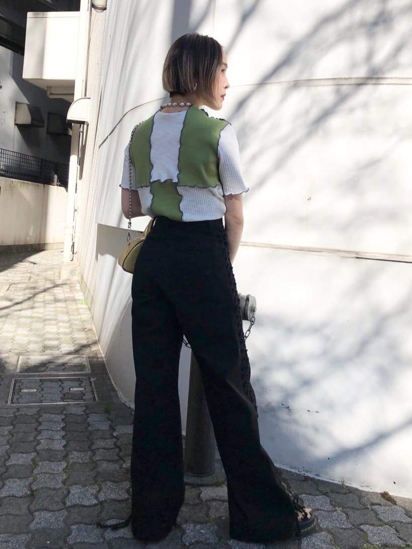 イエロー系のボストンバッグ、ブラック系のデニムパンツ、グリーン系のTシャツ/カットソーを着用したレディースの夏コーディネートの4枚目の写真