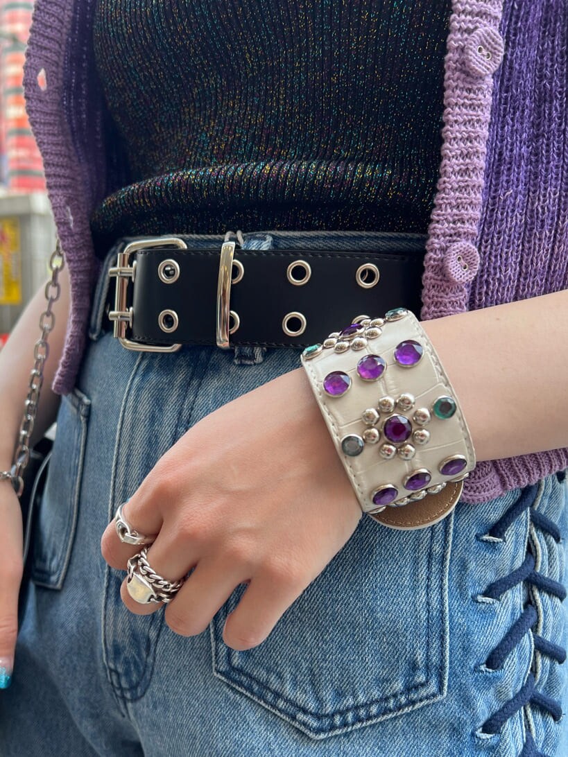 ブラック系のハンドバッグ、ブラック系のニット/セーター、ブルー系のデニムパンツを着用したレディースの夏コーディネートの10枚目の写真