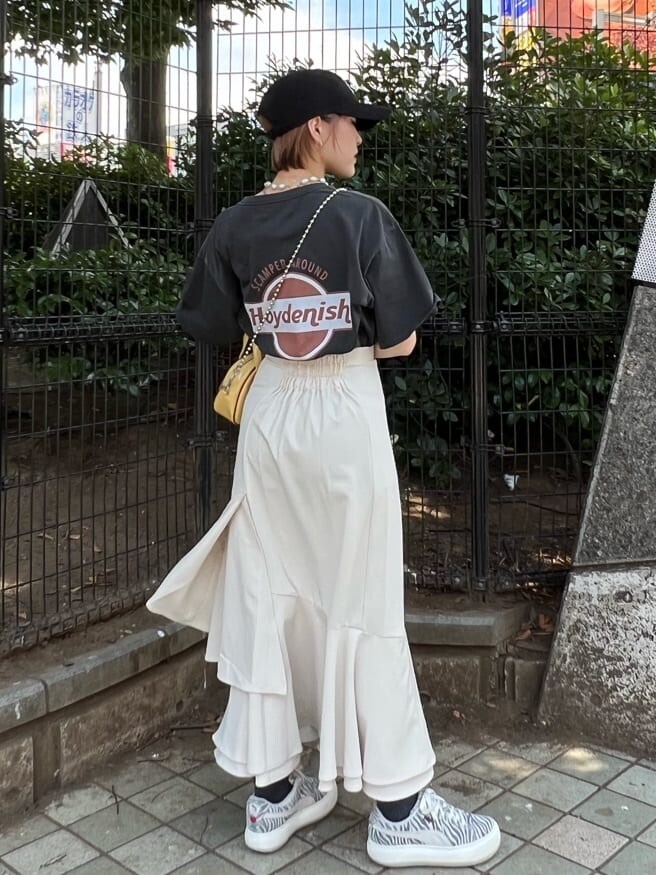 ホワイト系のスカート、イエロー系のボストンバッグ、ブラック系のTシャツ/カットソーを着用したレディースの夏コーディネートの4枚目の写真