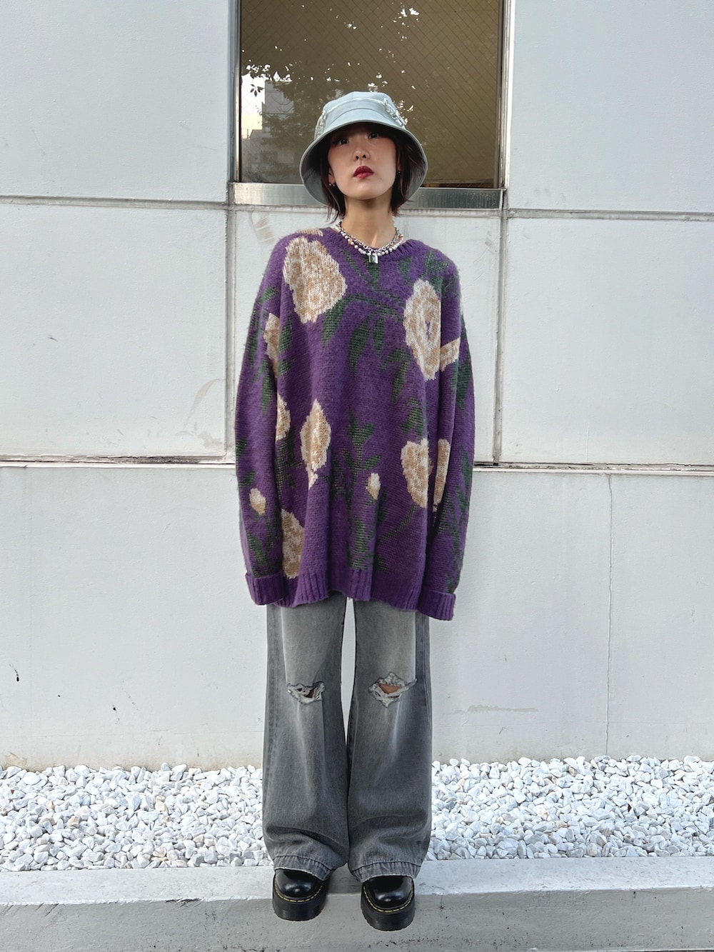 ブラック系のデニムパンツ、パープル系のニット/セーターを着用したレディースの秋コーディネートの2枚目の写真