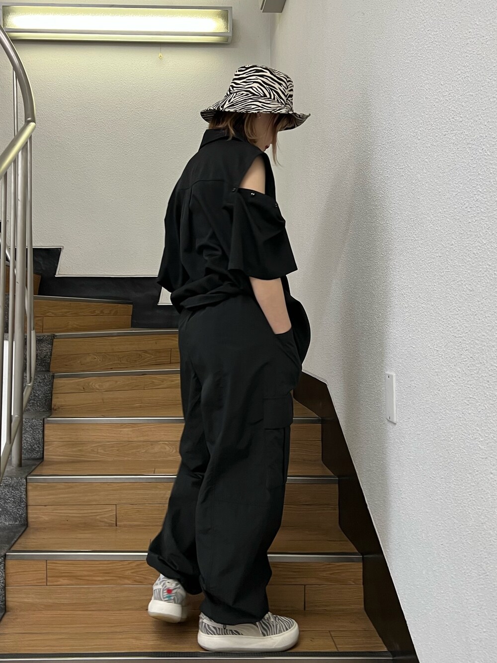 ブラック系のカーゴパンツ、ブラック系のシャツ/ブラウス、ホワイト系のハットを着用したレディースの春コーディネートの5枚目の写真