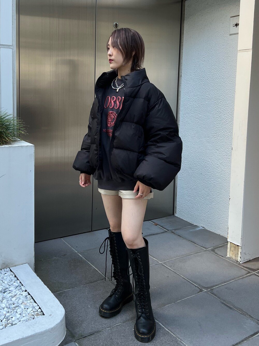 ブラック系のブルゾン、ブラック系のスウェット、ホワイト系のその他パンツを着用したレディースの冬コーディネートの2枚目の写真