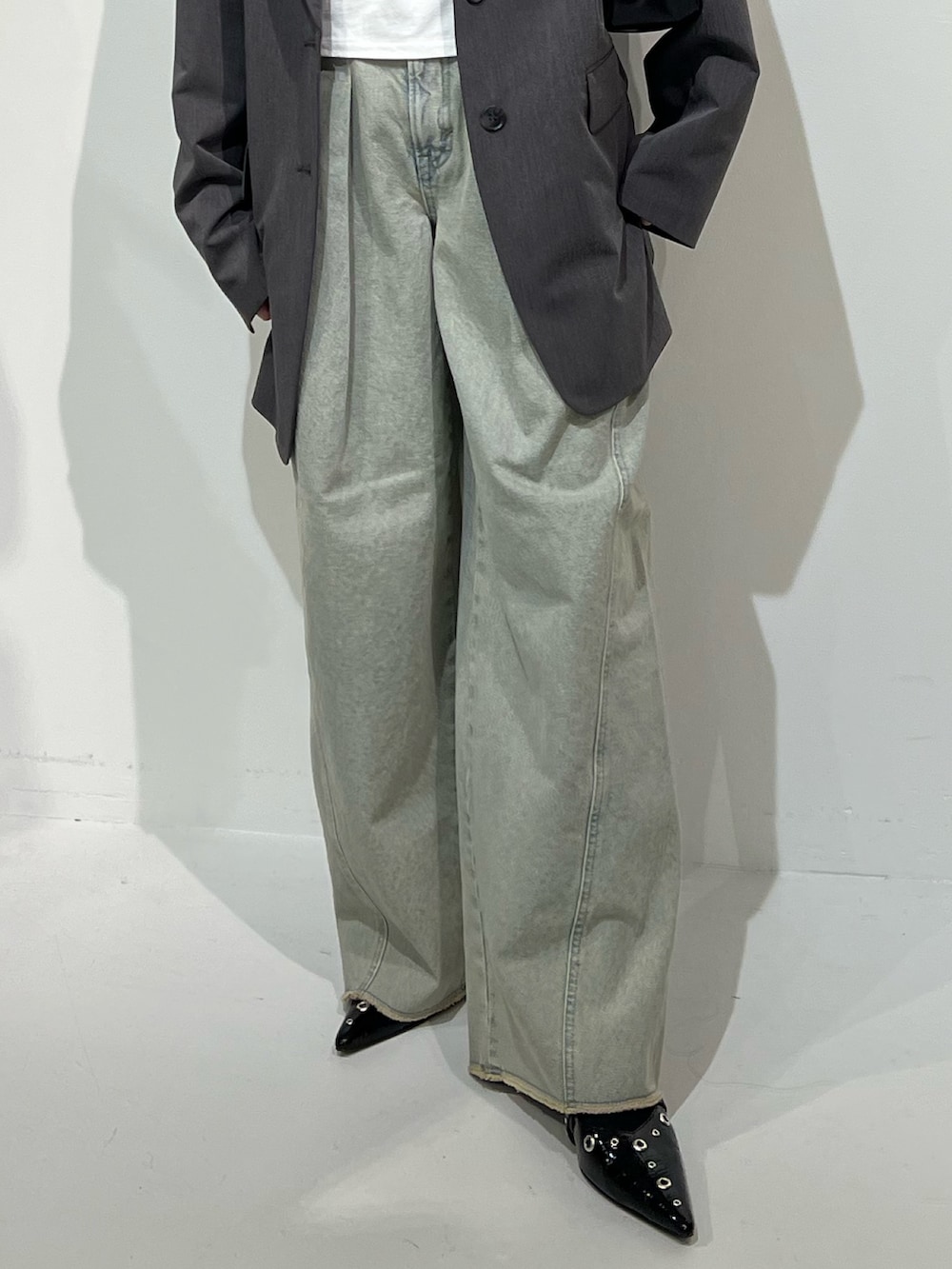 グレー系のテーラードジャケット、ブラック系のパンプス、ブルー系のデニムパンツを着用したレディースの春コーディネートの7枚目の写真