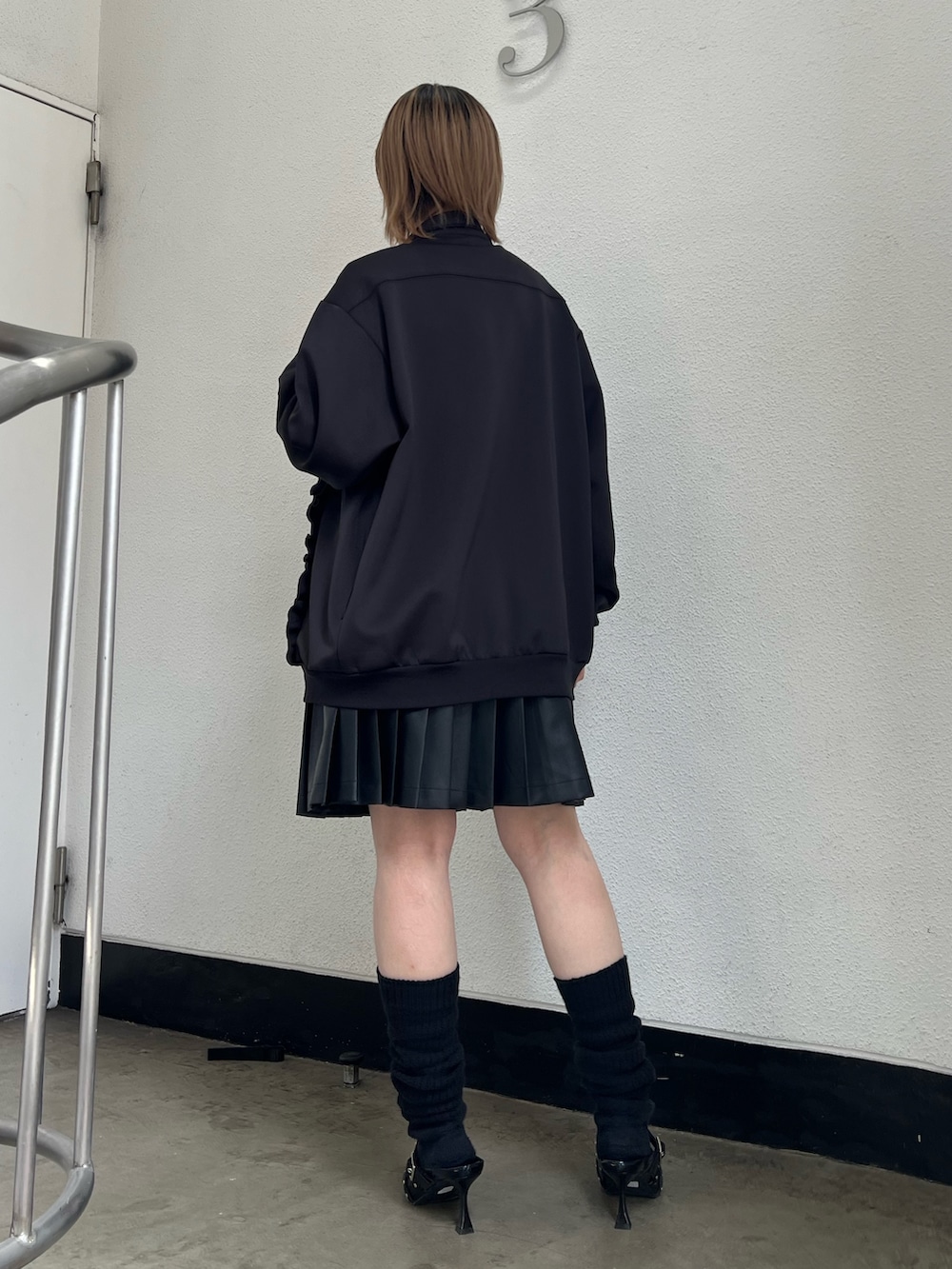 ブラック系のジャージ、ブラック系のパンプス、ブラック系のスカートを着用したレディースの春コーディネートの4枚目の写真