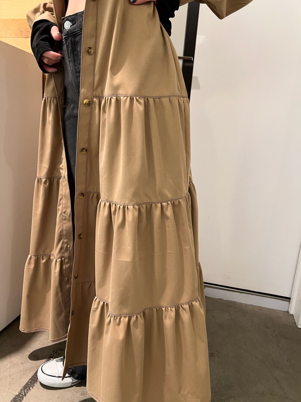 ブラック系のデニムパンツ、ブラック系のTシャツ/カットソー、ベージュ系のワンピースを着用したレディースの秋コーディネートの7枚目の写真