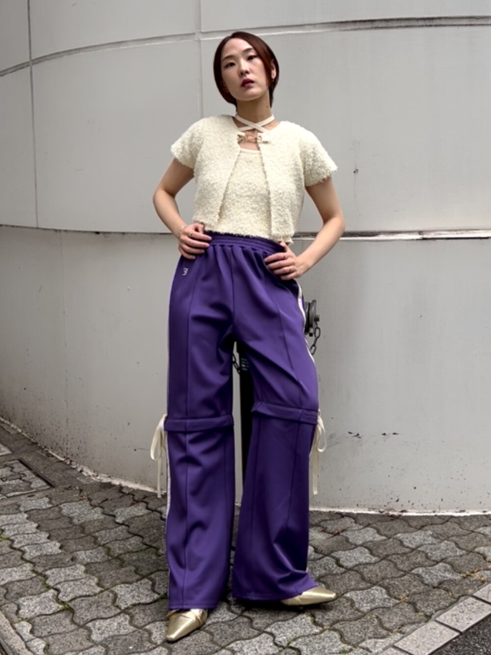 ホワイト系のアンサンブル、パープル系のその他パンツ、ゴールド系のパンプスを着用したレディースの夏コーディネートの8枚目の写真